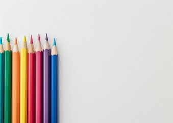 Fototapeta premium Colored pencils arranged on a white background The vibrant colors include orange, yellow, pink, green, blue, and purple, creating a visually appealing display for creativity