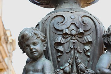 Obraz premium Black cherub figurines on a vintage lantern base