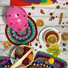 Cozy autumn photo with a cup of tea, flashlight, knitting, leaves and decor 