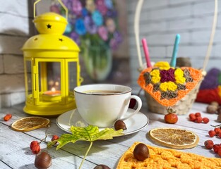 Cozy autumn photo with a cup of tea, flashlight, knitting, leaves and decor 