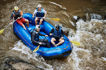 Raft, river and people in boat with rocks for fun adventure, holiday and outdoor vacation with friends. Extreme sports, travel and group in water for canoeing, kayaking and rowing activity in lake