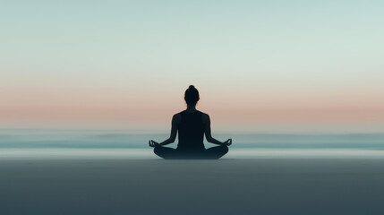 Silhouette of a person in a seated meditation pose on a calm beach at dawn. The sky transitions from soft pink to blue hues, creating a peaceful and reflective atmosphere along the horizon.