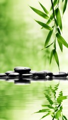 Naklejka premium a green background for relaxation, bamboo stalks in the reflection of water and smooth dark oval-shaped stones. a background for relaxation and relaxation, for the presentation of goods