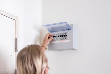 A man turns on a switch on an electrical panel in a room. Distributor Electricity.