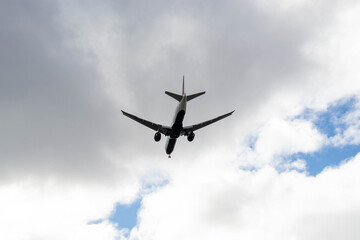 White passenger airplane flying in the sky amazing clouds in the background