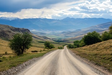 Fototapeta premium Scenic Dirt Road Leading to Mountains Under Blue Sky with Clouds