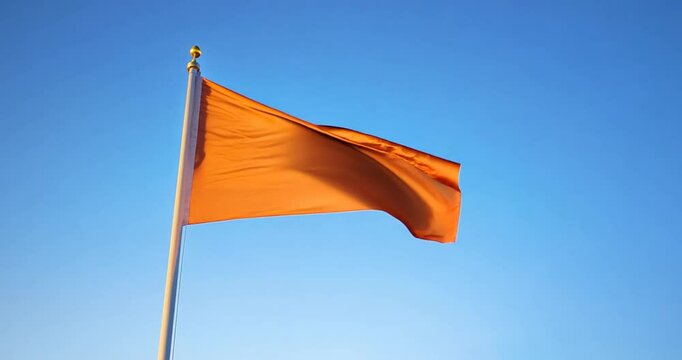 orange flag flying with blue sky background