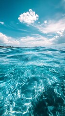 Fototapeta premium Turquoise ocean water with white clouds in blue summer sky