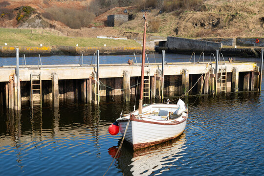 A small white boat moored in Lybster harbour Scotland