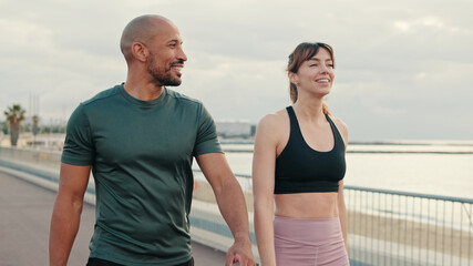 Close-up of an active young sporty couple have dialog, two athletes enjoy conversation and walking