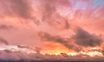 A beautiful sky tinted by the sun leaving vibrant shades of gold, pink, blue and multicolored. Clouds in the twilight evening and morning sky. Cloudy sky background in the evening, and during the day.