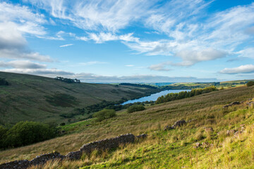  Scenic view of rolling hills and a reservoir in the Peak District National Park, UK.