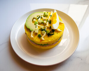 A plate of causa rellena with tuna, avocado, egg, and yellow
potato