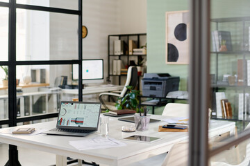 Modern office interior featuring an open workspace with glass partitions, workstations, and...