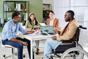 Group of business professionals sitting around table, engaging in important meeting. People...