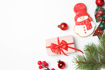 Flat lay composition with Christmas decor, gift box and delicious cookie in shape of snowman on white background, space for text