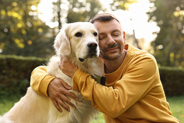 Man with cute Golden Retriever dog on spring day