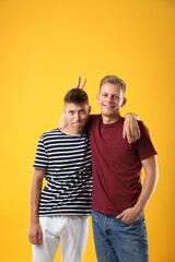 Portrait of funny brothers on orange background