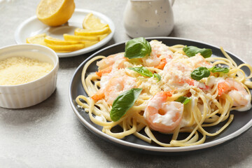 Tasty pasta with shrimps on light grey table, closeup