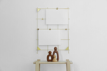 Mood board with blank paper notes and decorative figures on wooden ladder near white wall