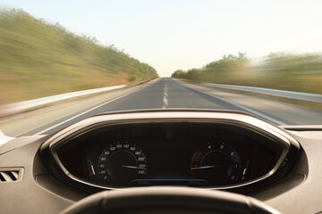 Car driving on empty road at high speed, view from driver's seat. Motion blur effect