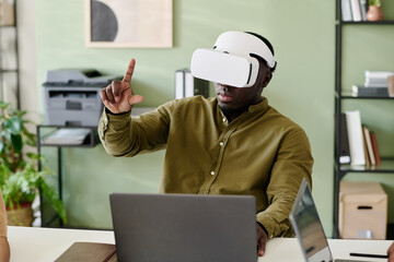 Person engaging with virtual reality in an office environment with bookshelves and printer in...