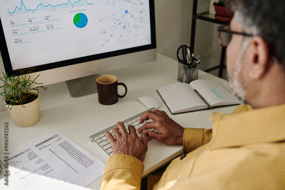 Aufkleber Detail of person analyzing financial data on desktop computer with charts and graphs visible on screen, working in bright and organized office environment, drinking coffee