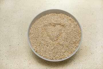 Oatmeal texture in a bowl with love in it, carbohydrates, top view with granite table base