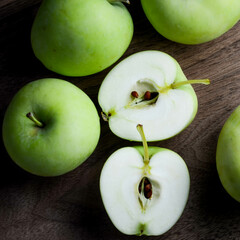 Lodi apples on a brown wood background, including a cut apple to show the interior.