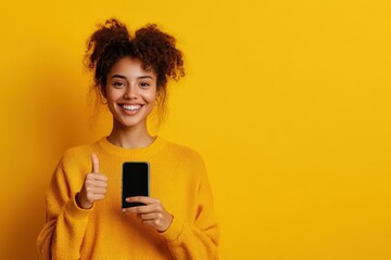 Fototapeta premium Beaming with Joy: Young Woman Posing with a Smartphone Against a Bright Yellow Background