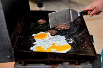 Cooking eggs and sausage on a flat top grill