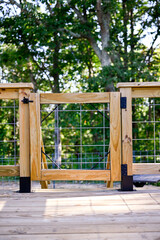 Wooden porch gate with grid wire railing. 