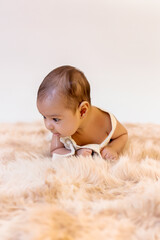 Two-month-old baby boy lying face down on furry rug