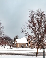 Snowy cozy and quaint house with trees in Ann Arbor, Michigan during the winter holiday season