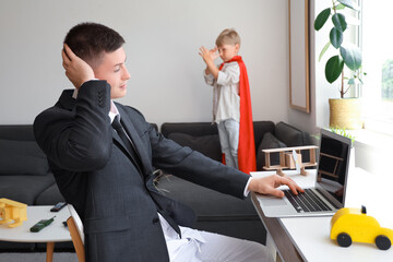 Working father stressed of his naughty little son at home