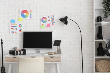 Photographer workplace with computer, color wheel charts and photo cameras in modern studio