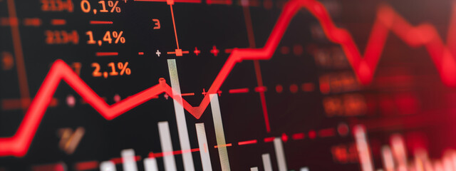 Close-up of a downward-trending line graph on a digital screen showing a significant drop in earnings, with blurred financial charts and data in the background, emphasizing the concept of economic dec