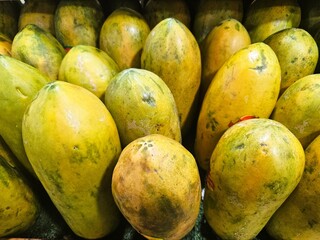 Ripe papaya fruit is neatly arranged in the market, Yellow ripe papaya fruit is sold in the market