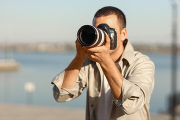 Male photographer with modern camera outdoors