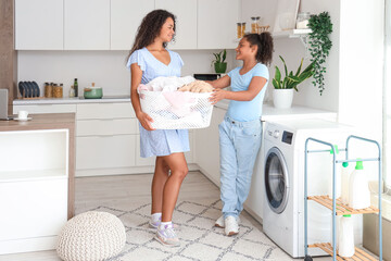 African-American woman and her daughter doing laundry at home