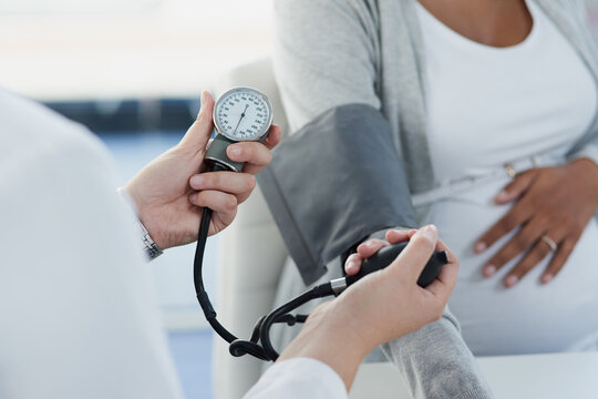 Healthcare, pregnant woman and doctor with appointment for blood pressure, monitor heart rate and checkup. Hospital, patient and obstetrician with consultation for pregnancy, hypertension or wellness