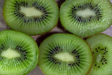 Fototapeta premium Close-up of fresh Green kiwi slices on a wooden table