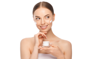 Young smiling beautiful woman with shoulders and cream on cheeks looking away, holding cosmetic jar