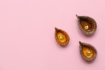 Diya lamps on pink background. Divaly celebration