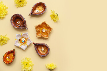 Diya lamps with flowers on yellow background. Divaly celebration