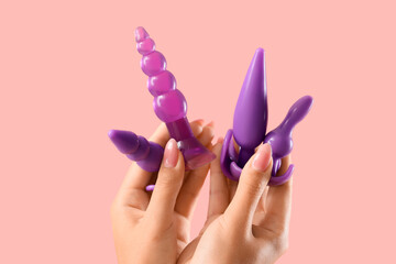 Woman with purple anal plugs on pink background