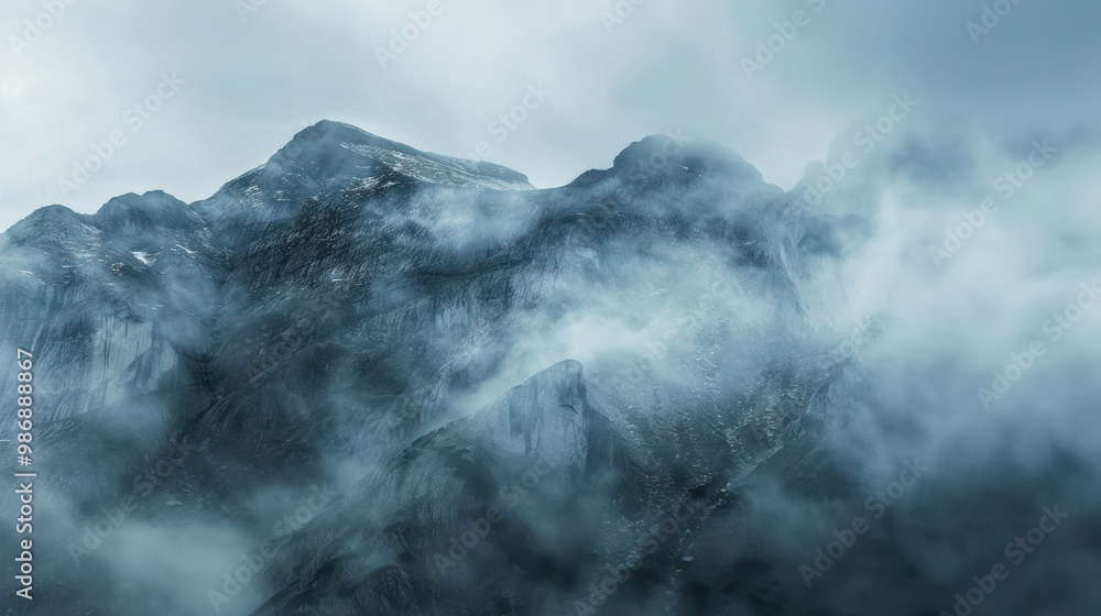 Poster a mysterious mountain range shrouded in fog and mist, creating a dramatic and atmospheric scene.