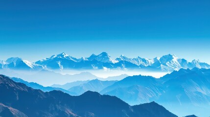 Obraz premium A panoramic view of snow-capped mountain peaks against a clear blue sky.