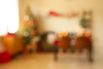 Blurred view of dining room with table, sofa and Christmas tree