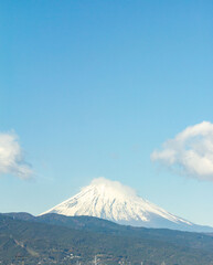 A majestic Mount Fuji stands tall against a clear blue sky ; Snow-capped Mount Fuji, a symbol of Japan, dominates the horizon.jpg